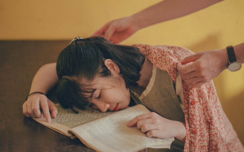 Kobieta śpi na książkach